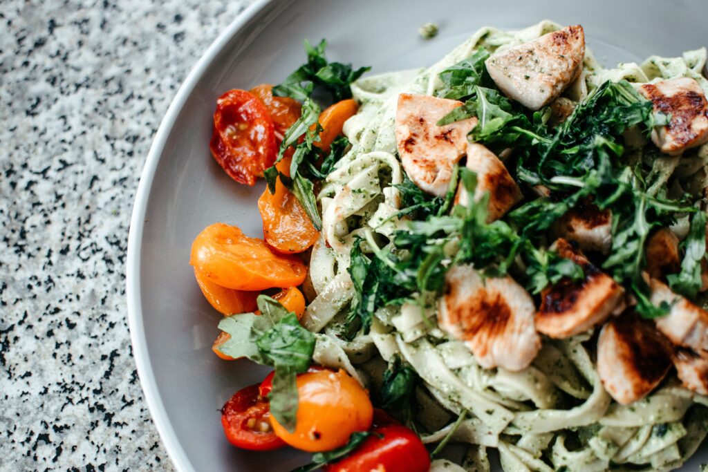 Quick & Easy Recipes: Savor a plate of chicken pesto pasta topped with fresh herbs and juicy cherry tomatoes.