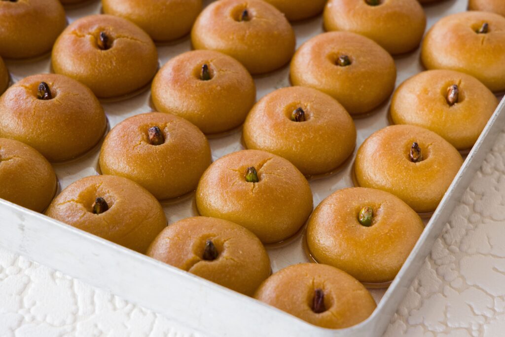Desserts & Sweets: Tray of freshly baked Şekerpare, a traditional Turkish dessert, with visible pistachio garnish.